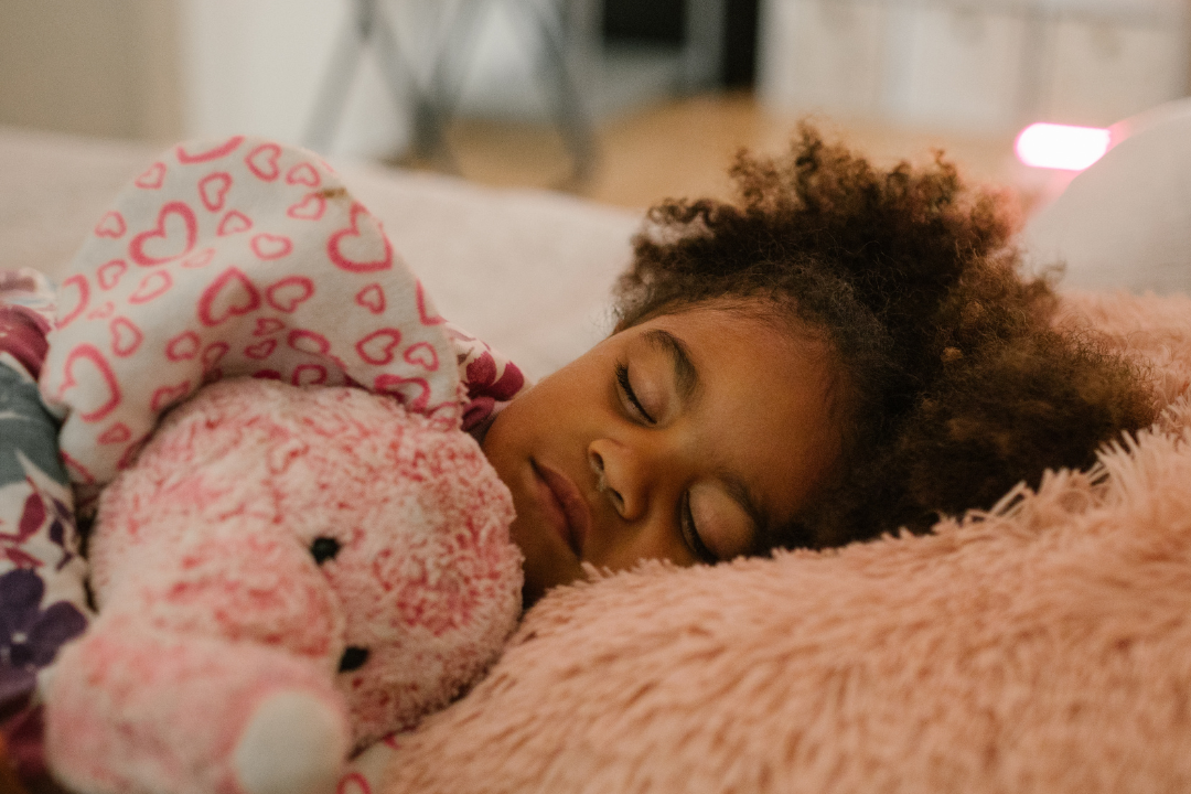 Young child sleeping peacefully in bed, illustrating the benefits of independent sleep for emotional resilience and cognitive growth.